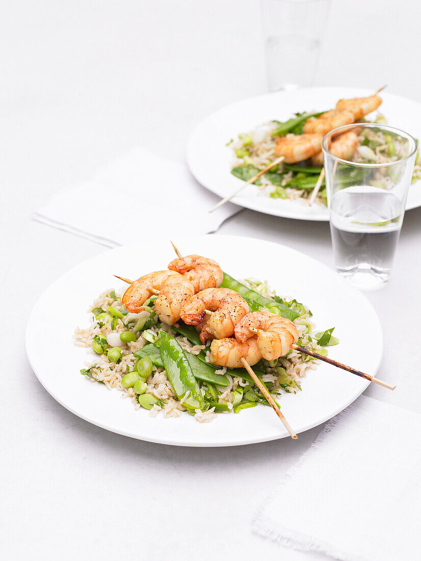 Miso shrimp skewers on rice salad with vegetables