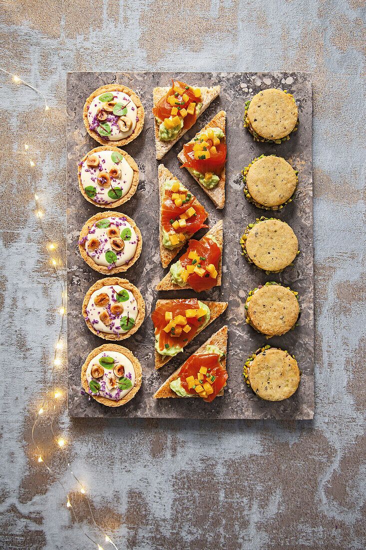 Canapes mit Blumenkohlcreme, Räucherforelle und Avocado, Pistazienplätzchen mit Mortadella