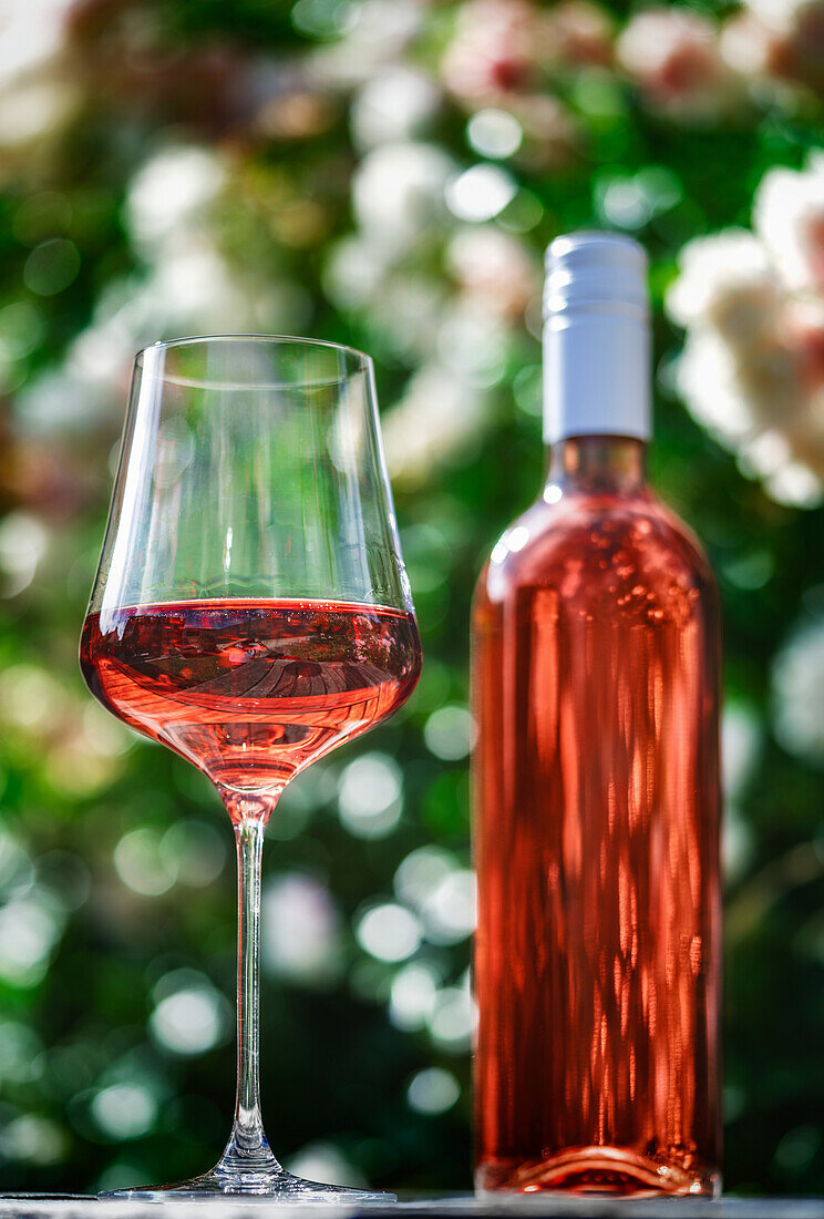 Ein Glas und eine Flasche Roséwein