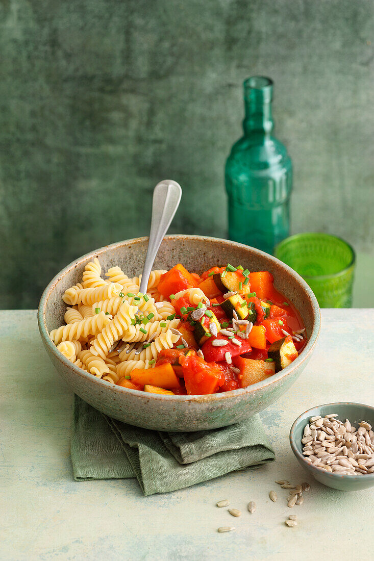 Veganes Gemüse-Gulasch mit Paprika, Zucchini und Kohlrabi serviert mit Nudeln