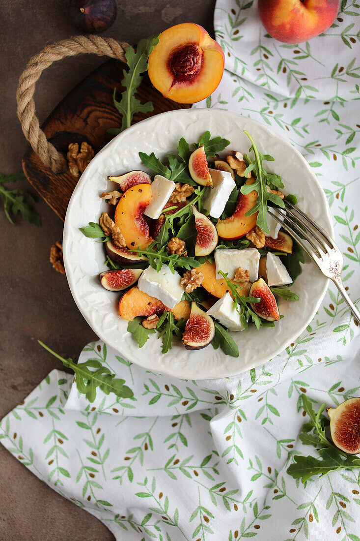 A light salad with rocket, peaches and brie cheese