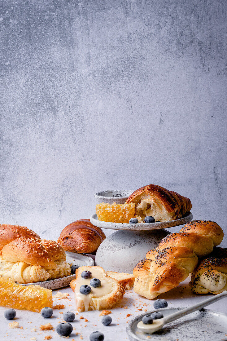 Hefezopf und Croissants mit Honig und Blaubeeren