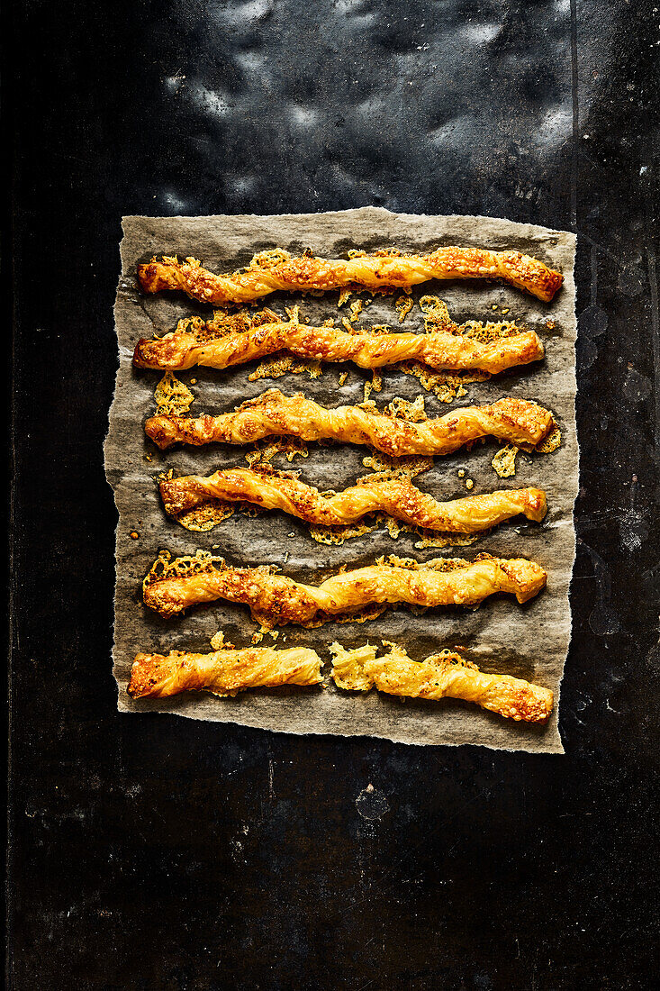 Cheese puff pastry sticks on parchment paper