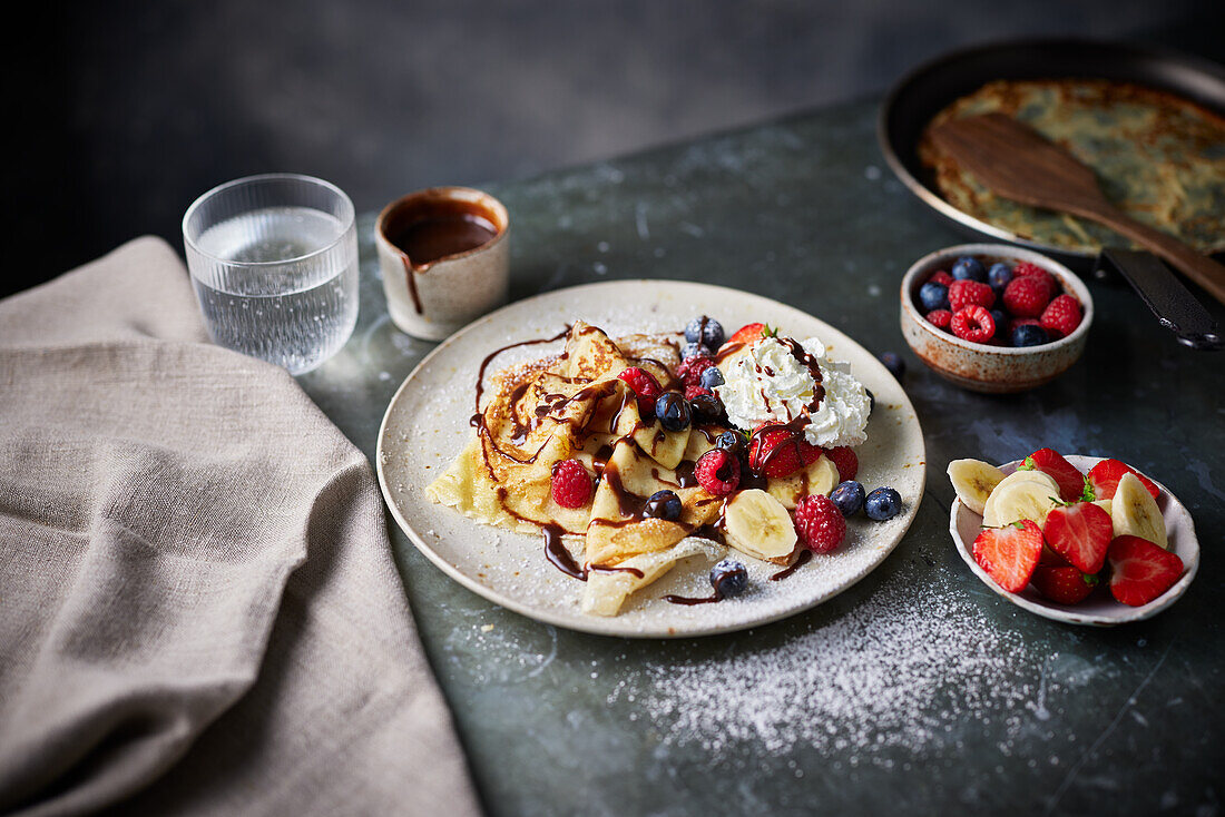 Classic Crêpes with fruit, chocolate sauce, and cream