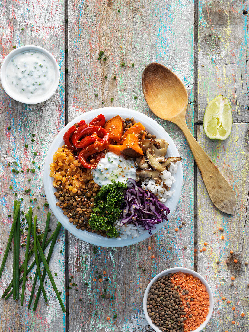 Vegan buddha bowl with chives, kale, lentils and peppers