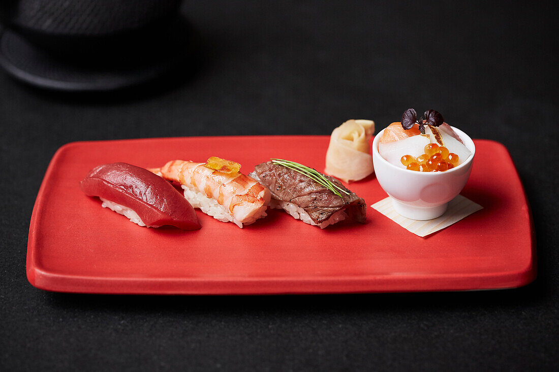 Nigiri-Sushi auf roter Servierplatte (Japan)