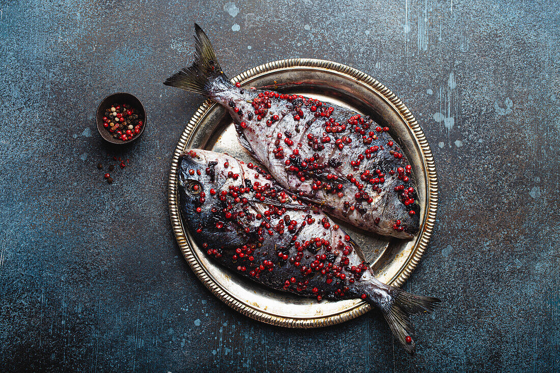 Two whole gilt-head breams seasoned with pink peppercorns (ready to cook)