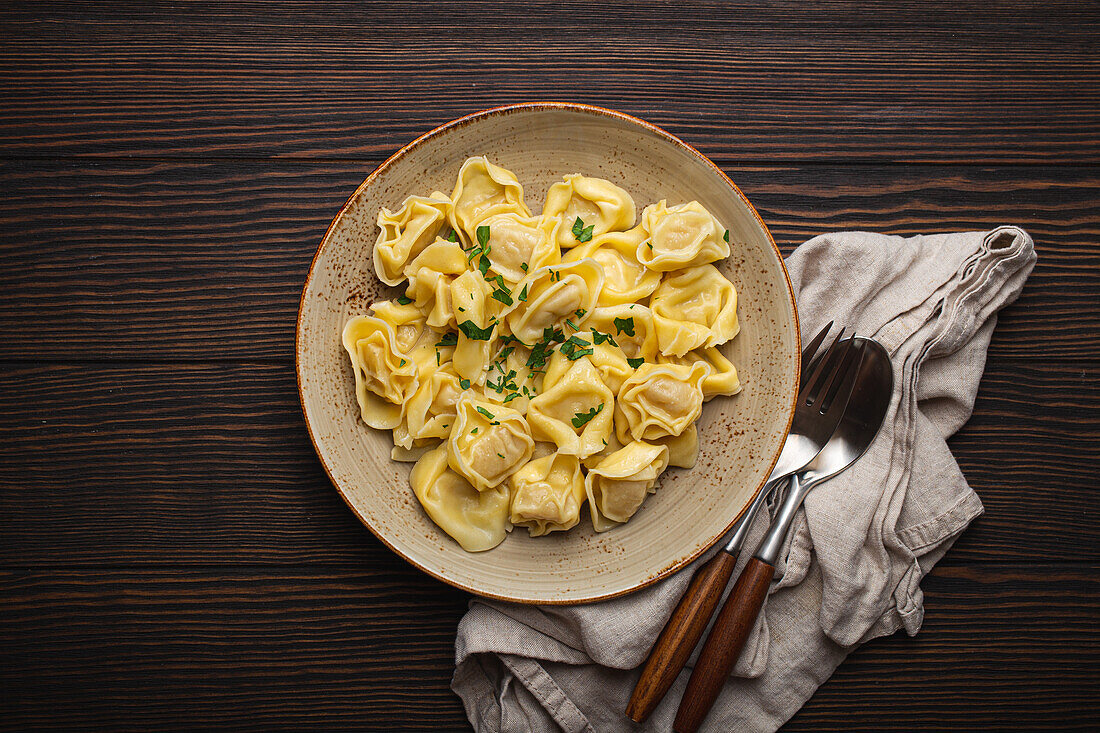 Tortellini with herbs on a ceramic plate
