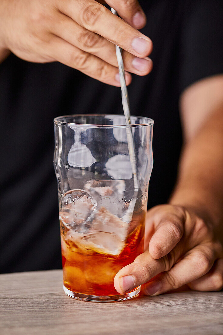 Making Old Fashioned cocktail, mixing with spoon