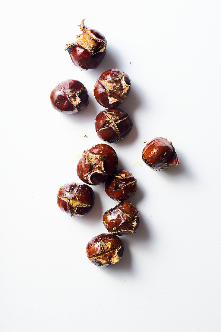 Flat lay with roasted chestnuts on white background