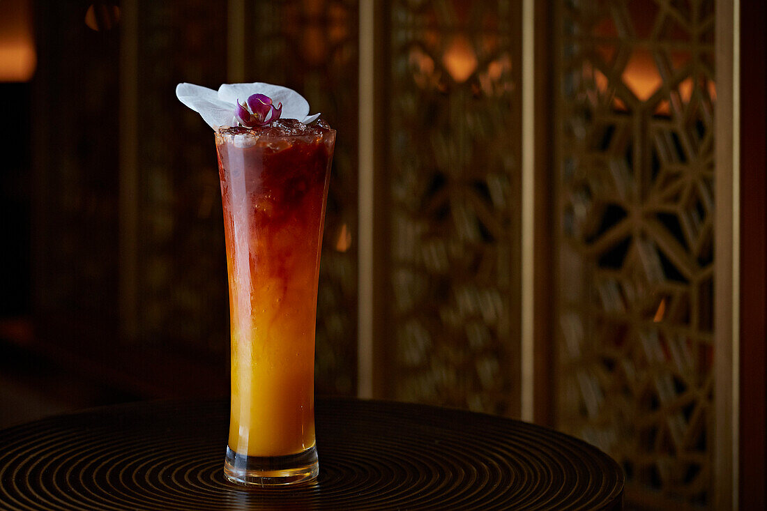 Elegant cocktail garnished with orchid blossom
