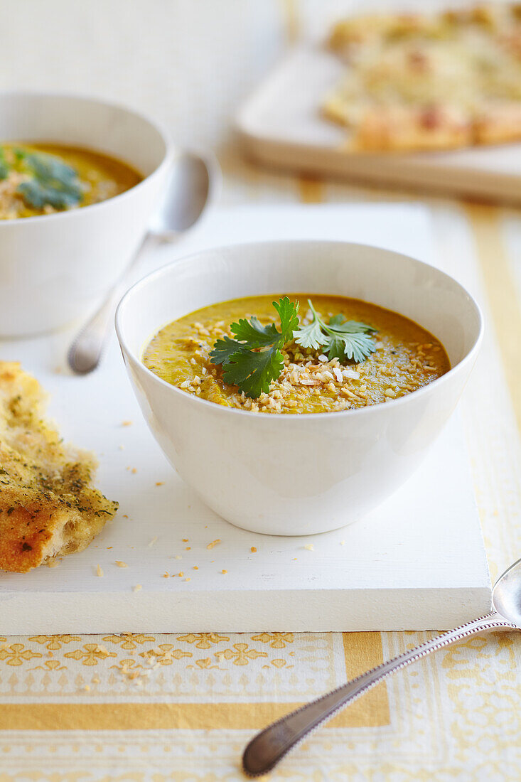 Vegane Kokos-Linsen-Currysuppe mit geröstetem Kokos und Korianderblättern