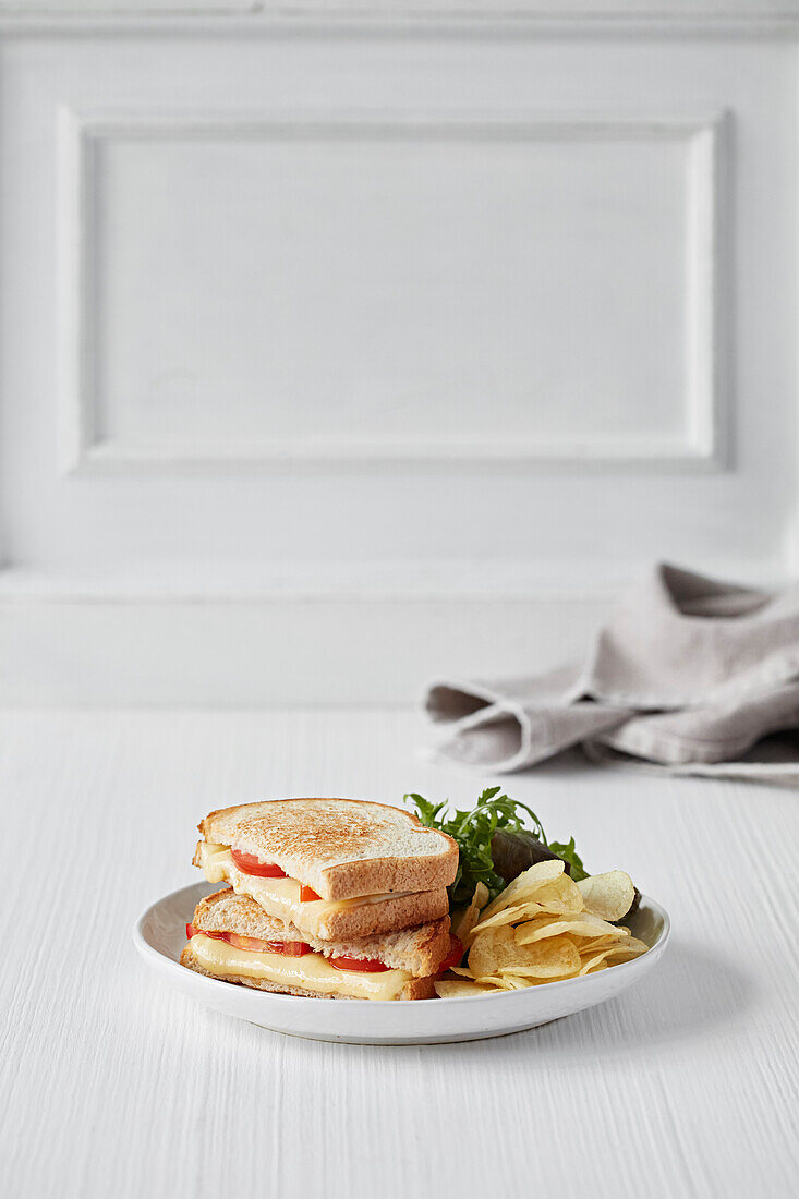 Cheese and tomato sandwich with crisps