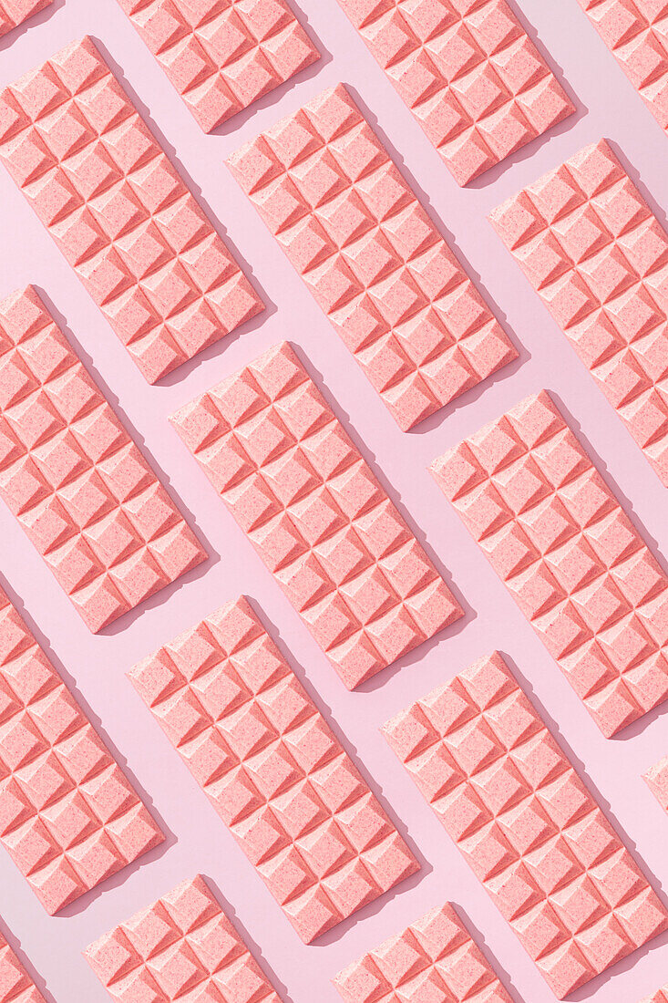 From above sweet pink chocolate bar on blue background