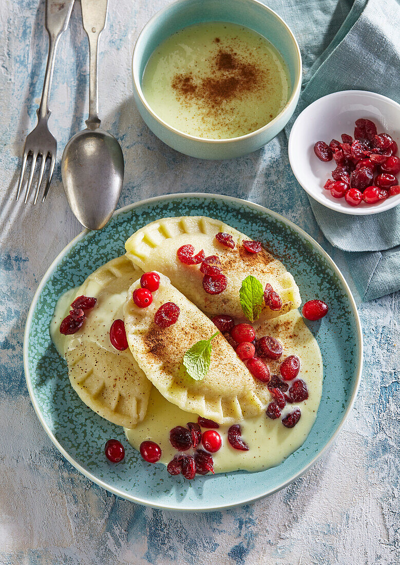 Süße Teigtaschen mit Cranberries und Vanillesauce