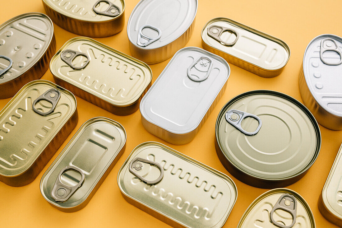 Top view row of unopened cans on a yellow background