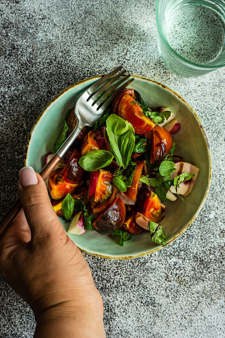 Bio-Gemüsesalat mit schwarzen Tomaten und Basilikum