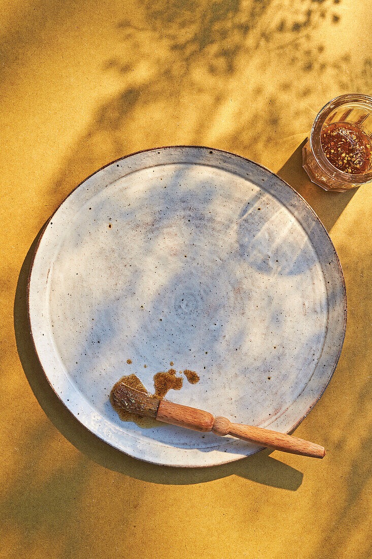 Pinsel mit Grillmarinade auf Keramikteller