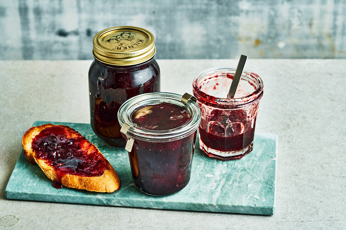 Zwetschgenmarmelade in Gläsern und auf Brot