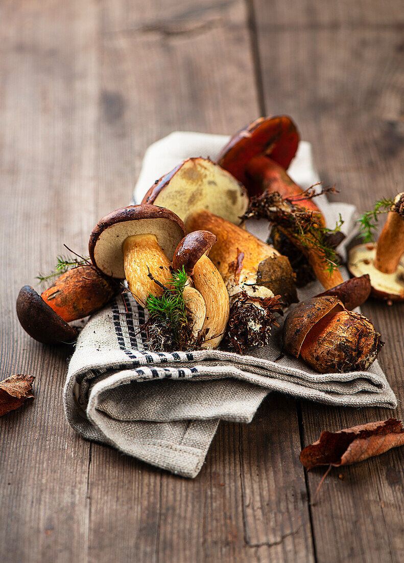 Mixed wild mushrooms on a cloth and wooden background