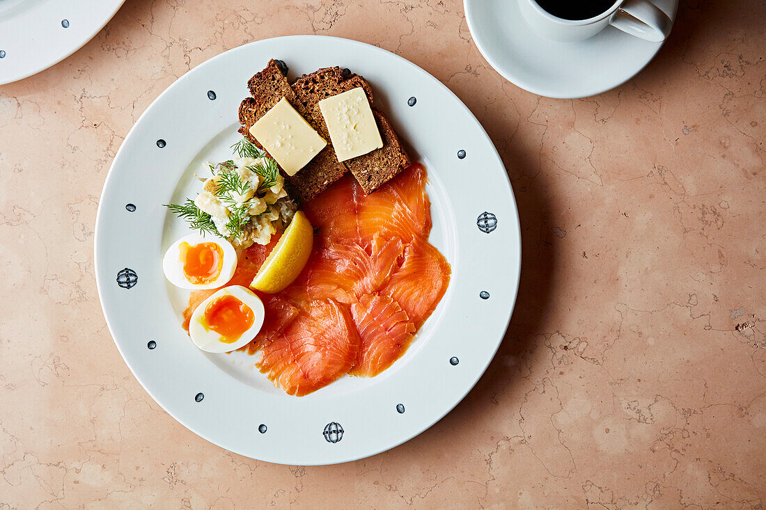 Breakfast plate with salmon, boiled eggs and rye bread