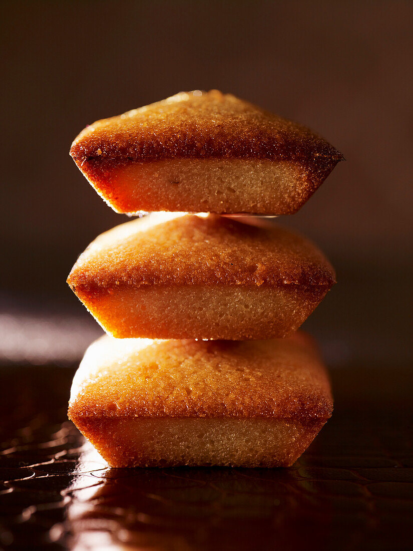 Financier, stacked in front of a dark background