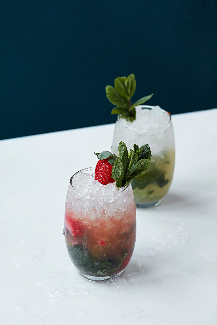 Zwei verschiedene Cocktails mit Minze und Crushed Ice