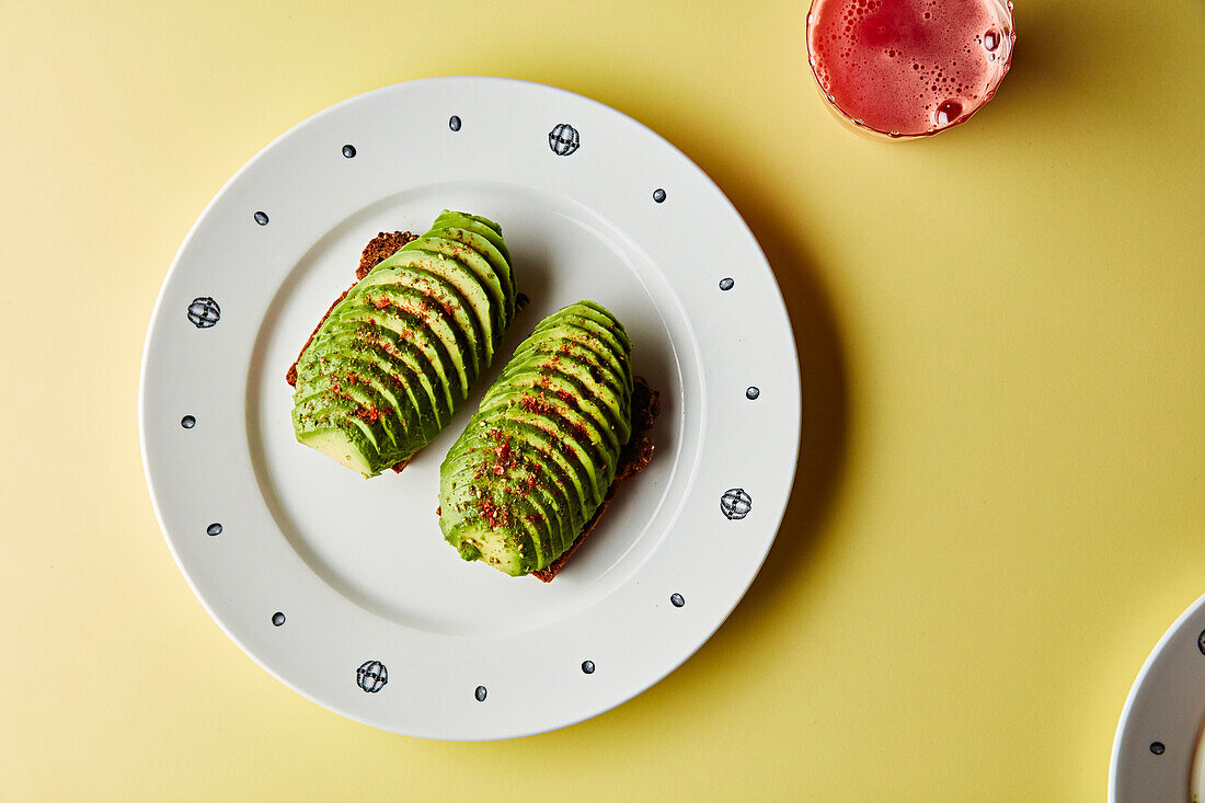 Avocado in Scheiben geschnitten auf Roggenbrot serviert