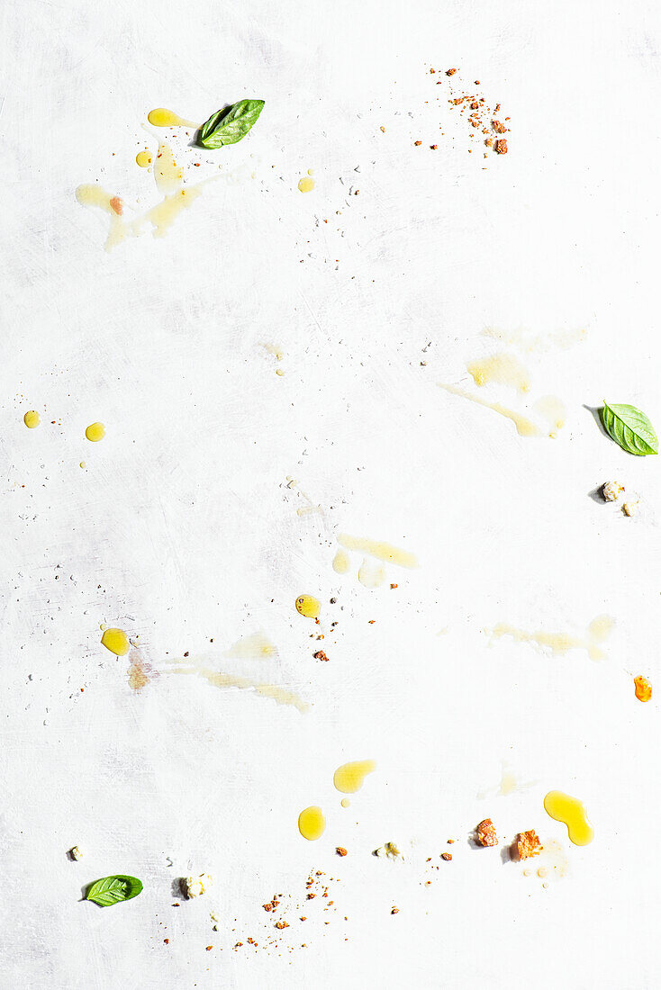 Breadcrumbs, basil, and olive oil on a light background