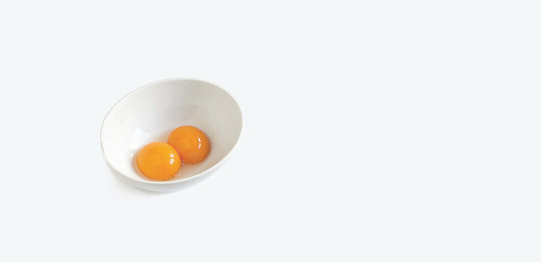 Two egg yolks in a small bowl