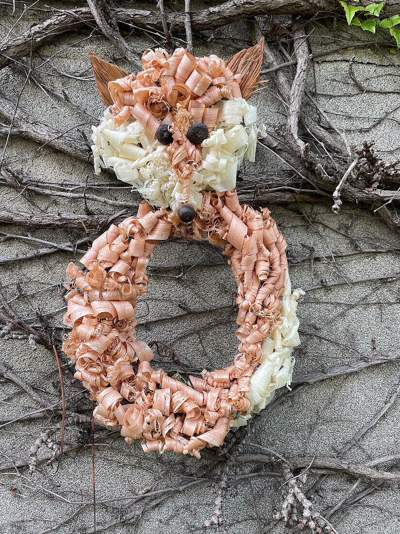 DIY door wreath with fox motif made from wood shavings