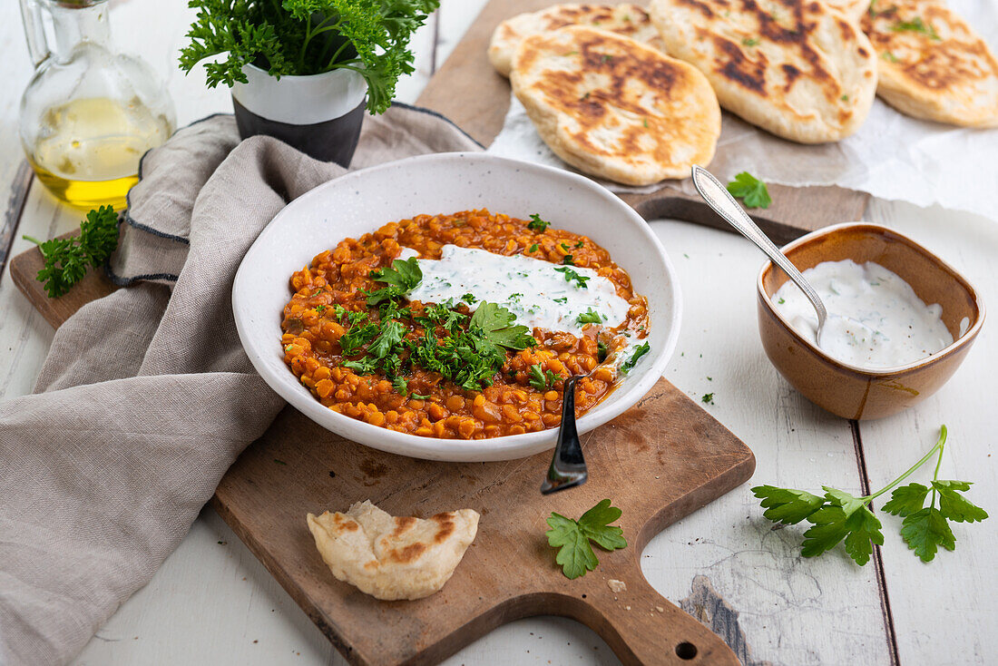 Veganes Rote Linsen Dal mit Kräuter-Kokos-Creme und Naan Brot (Indien)