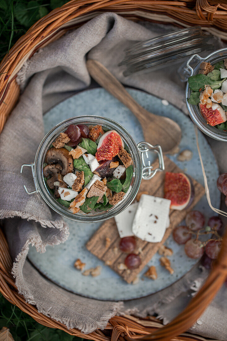 Autumn bread salad with figs, grapes, and cheese served in a bow glass