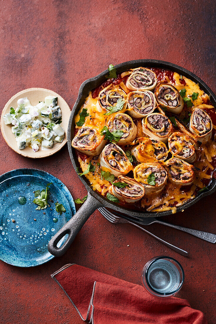 Enchiladas filled with bean puree in tomato sauce