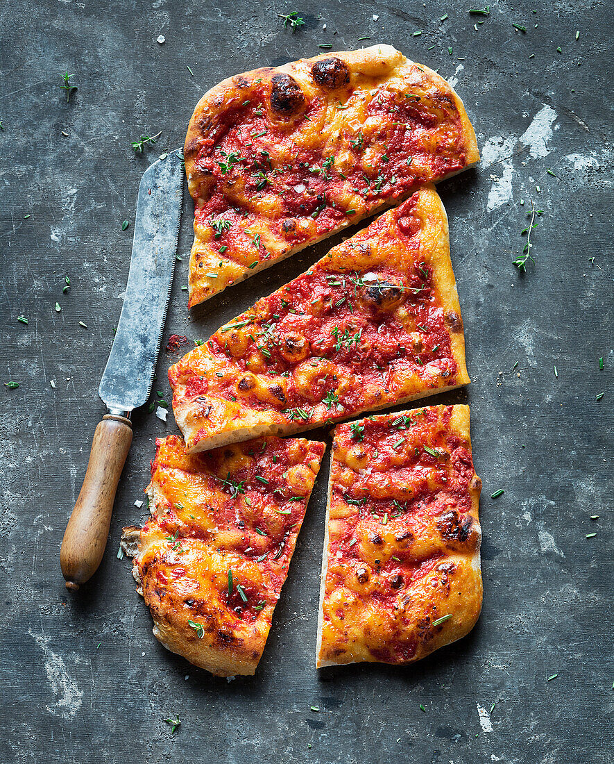 Pizza mit Tomatensauce, Oliven und Kräutern