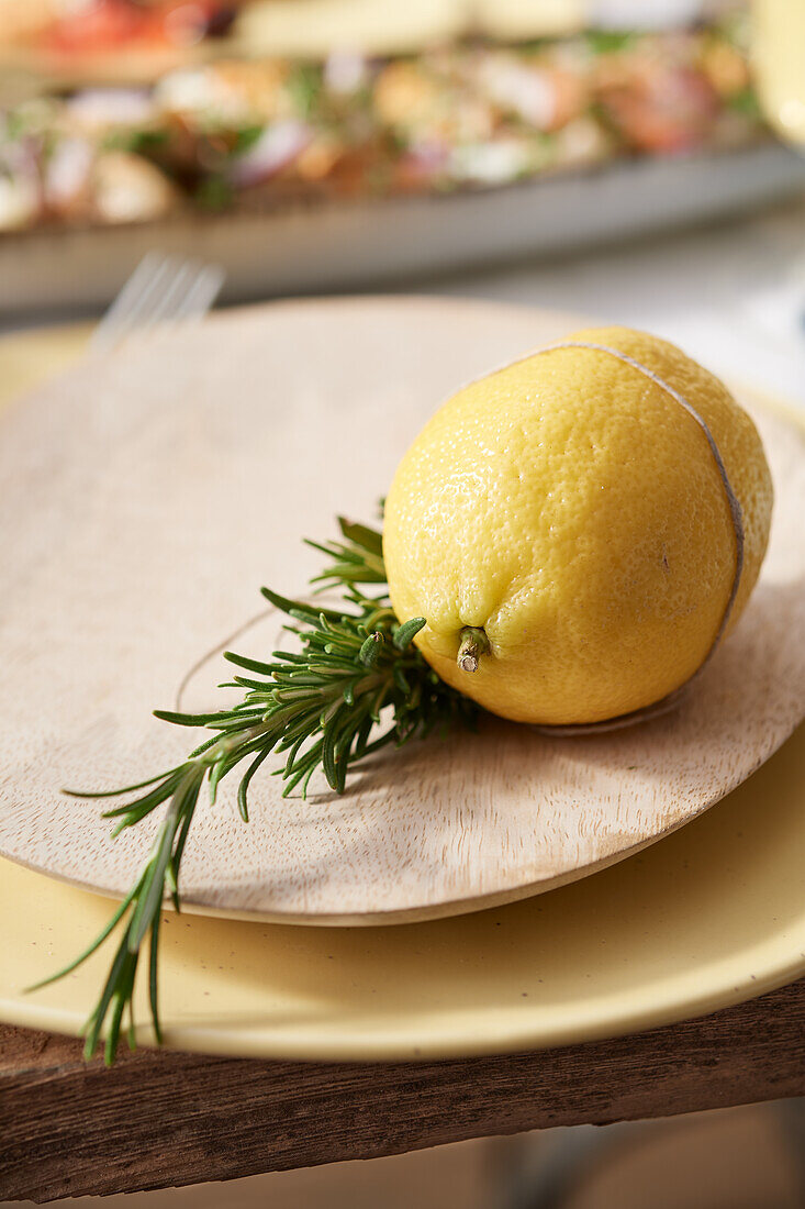 Mediterrane Tellerdeko aus Zitrone und Rosmarin