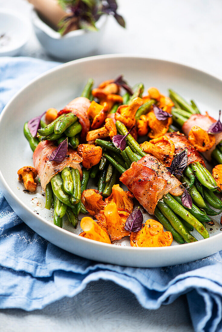 Green beans wrapped in bacon with chanterelles