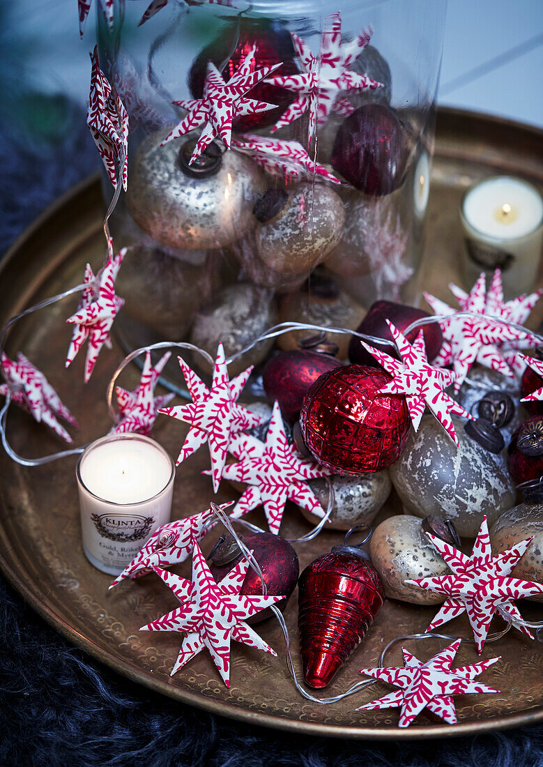 Rot-weiße, sternförmige Lichterkette und Christbaumanhänger