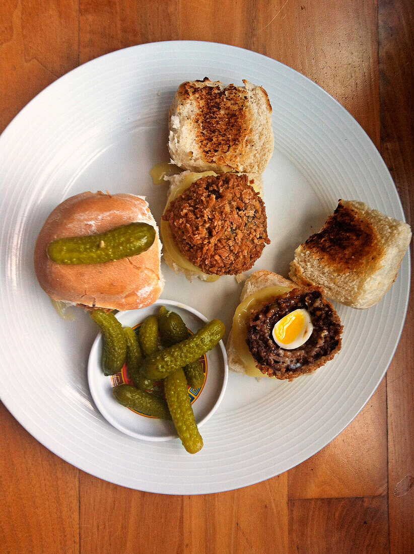 Sliders with a black pudding patty, quail's egg and gherkins