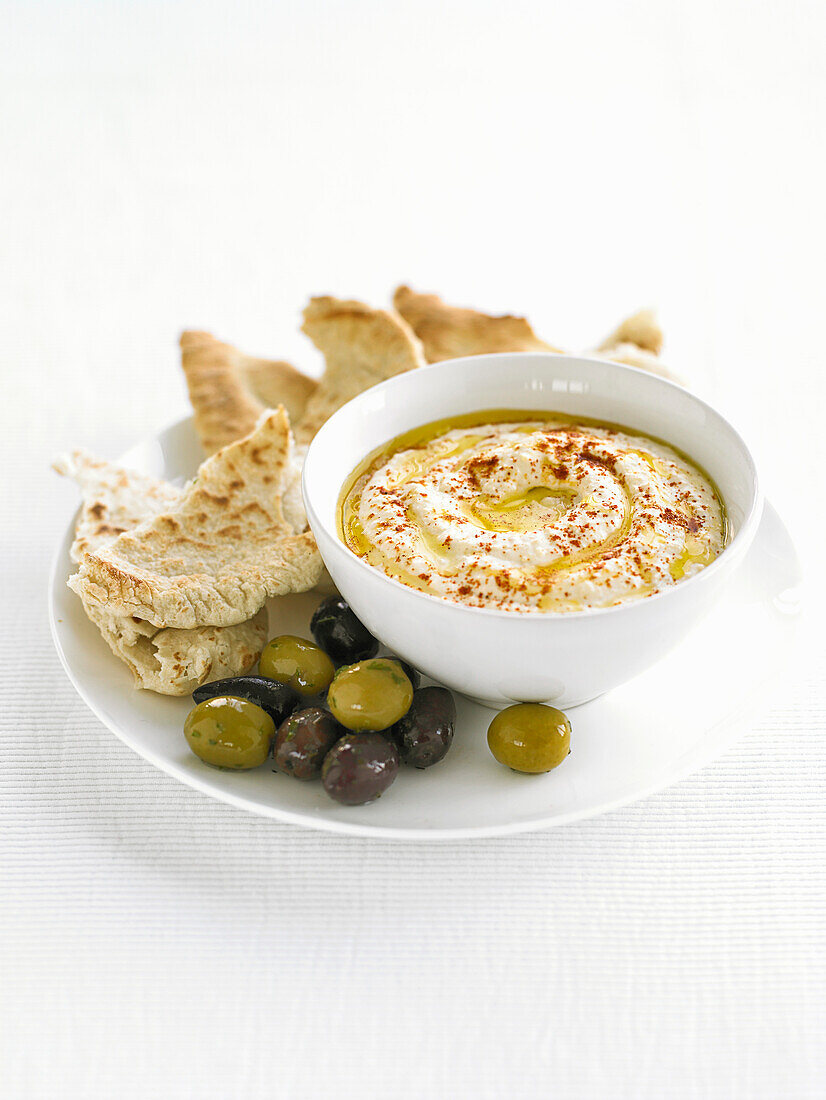 Hummus with warm pita bread and olives