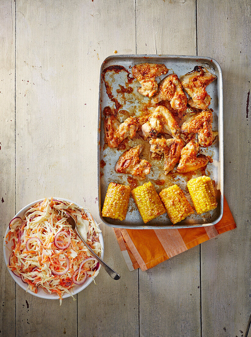 Roast chicken wings with corn cobs and coleslaw