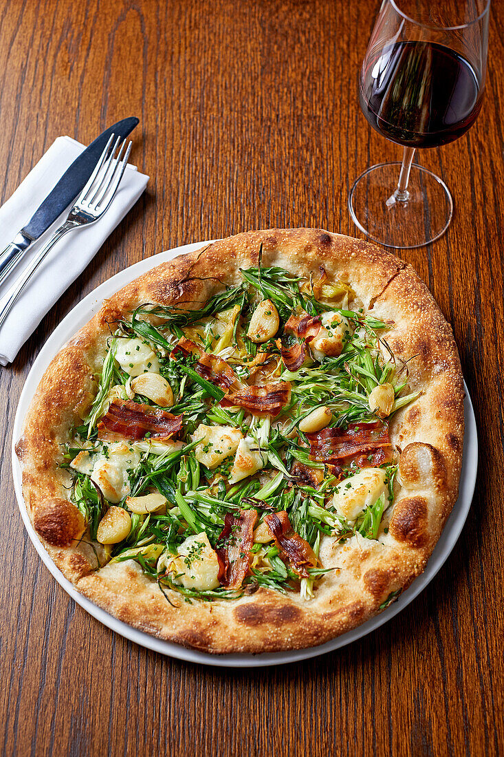 Pizza with goat's cheese, leeks, spring onions, garlic and pancetta