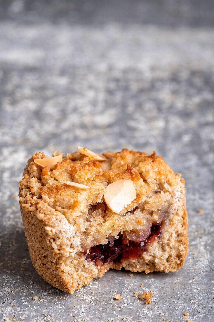 Gluten-free mini raspberry bakewell tartlets, bitten into