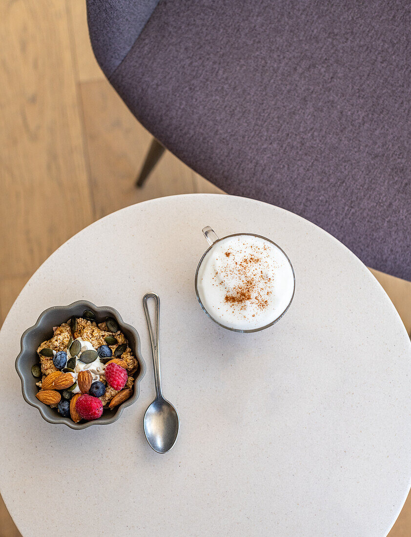 Granola mit Beeren dazu ein Flat White