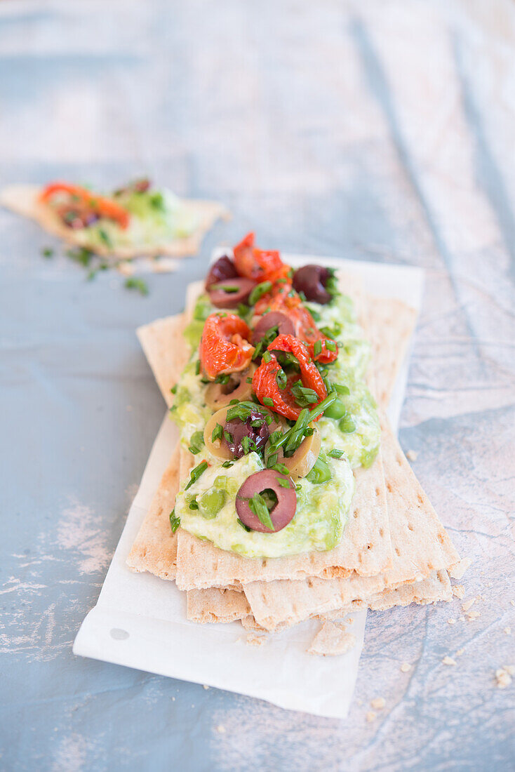 Crispbread with pea curd, semi-dried tomatoes and olives