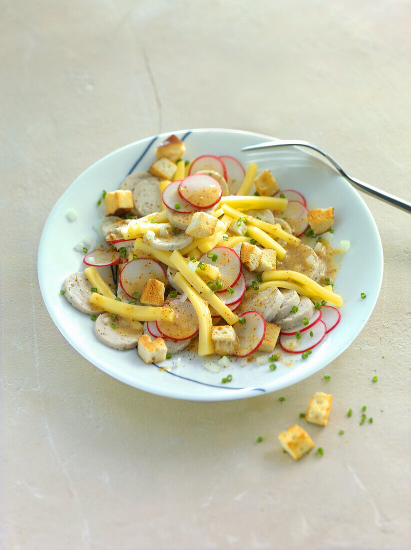 White sausage salad with radishes, cheese, and croutons