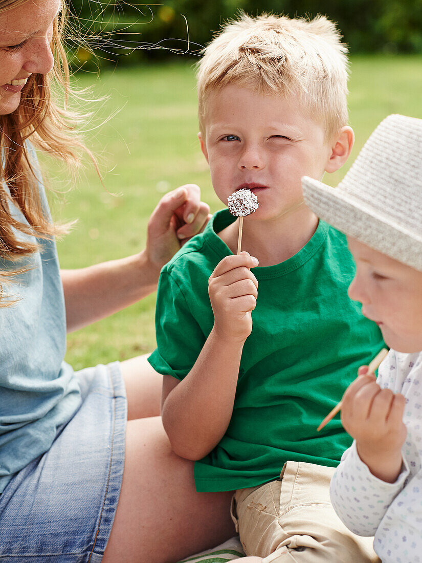 Boy eating berry skewers with chocolate coating