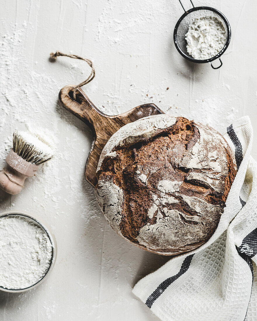 Crusty bread with baking utensils and a cloth