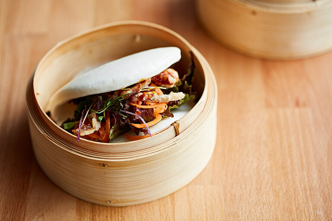 Bao buns presented in wooden steaming baskets