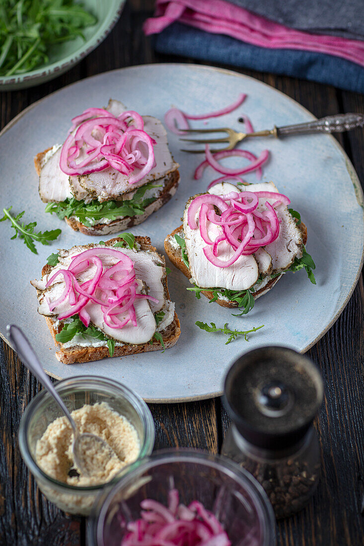 Bread with arugula, baked turkey and pickled onion